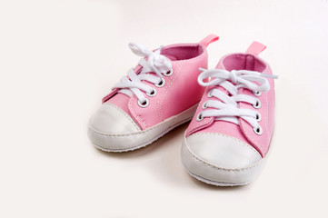 Fototapeta na wymiar Cute pink baby girl sneakers close up on gray background