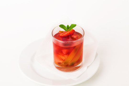 glass compote with strawberries, apples and mint, fruit, pear, jelly, juice, isolated on a white background for the menu