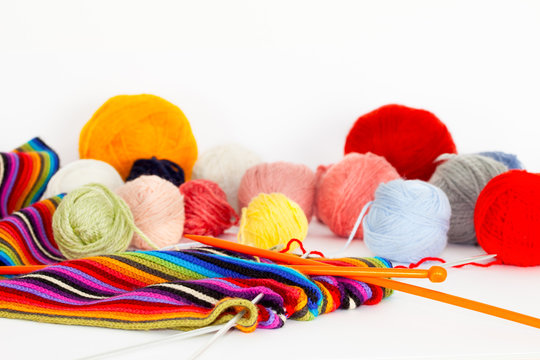 Knitting scarf with colorful  threads and knitting needles 