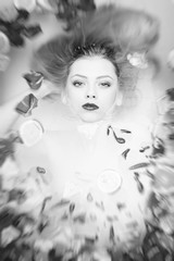 Black and white portrait of luxury spa queen with silk skin having fun laying in water bath, close up picture