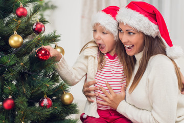 Mother And Dughter Decorating Christmas Tree