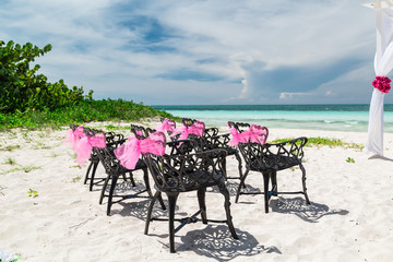Fototapeta na wymiar amazing gorgeous inviting view of wedding decorated old vintage retro black chairs standing on tropical Cuban beach against tranquil ocean and beautiful blue sky