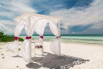 Fototapeta na wymiar beautiful, amazing gorgeous inviting view of wedding decorated gazebo against tranquil turquoise tender ocean and blue sky background