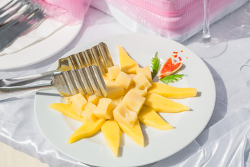 amazing appetizing view of fresh cheese pieces with mango on white ceramic plate