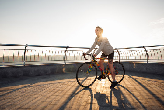 Young woman cycling in the morning city