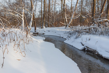 A small river in the winter forest winter sunset