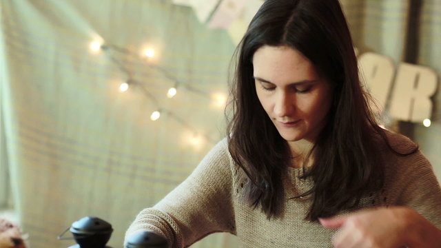 Young Woman Wrapping Christmas Gifts At Home
