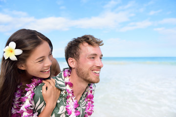 Beach couple having fun piggybacking Hawaii travel