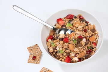 Muesli cereals bowl and spoon with almond, pine nuts, walnut, ra