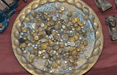 old buttons of different forms on a brass plate on a flea market in Lisbon, Portugal