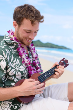 Man on Hawaiian beach playing ukulele on Hawaii