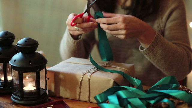 Women's Hands Wrapping Christmas Gifts At Home