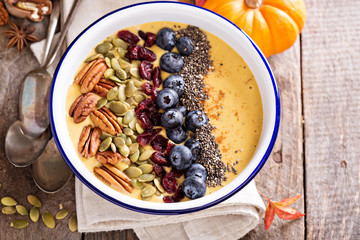 Pumpkin smoothie bowl with chia seeds, pecans, cranberries