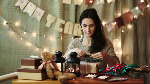 Young Woman Wrapping Christmas Gifts At Home