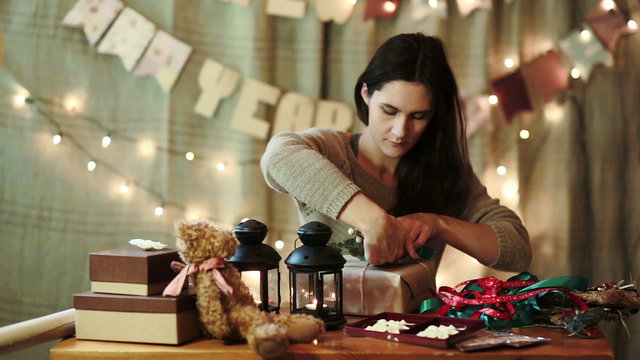 Young Woman Wrapping Christmas Gifts At Home