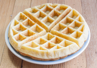 Full waffle with blue dish on the wooden background