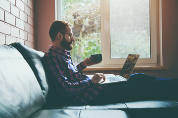 bearded man with laptop drinking coffee or tea