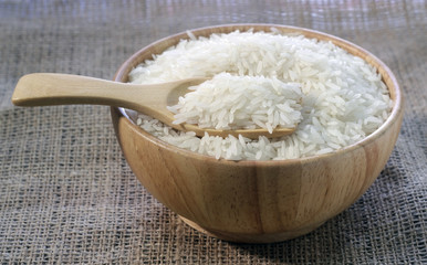 Rice in a wooden bowl on sackcloth  background