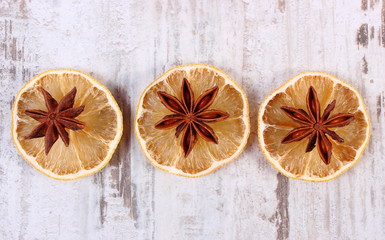 Slices of dried lemon and star anise on old wooden background