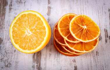 Dried and fresh orange on old wooden background