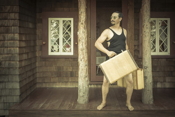 Gentleman Dressed in 1920’s Era Swimsuit Holding Suitcases on