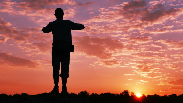 Man  tourist , prayer,with  raised hands  at sunrise, sunset time. 4K 3840x2160

