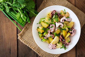 Potato salad with pickled octopus and green onions. Top view