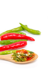 Chopped chili on wooden spoon with green and red chili isolated