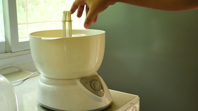 Father hand input nipples and milk bottles into steaming sterilizer for cleaning
