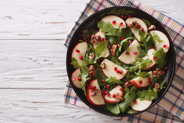 salad with apples, pomegranates, walnut and arugula. horizontal top view
