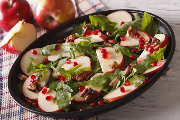 Apple salad with pomegranate, nuts and arugula close-up. horizontal
