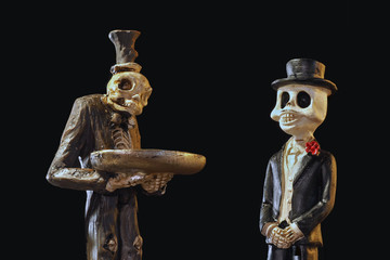 Страшные игрушки скелеты в одежде. Официант с подносом, джентельмен мужчина. Скелет в фраке, шляпе. Заготовка, шаблон на черном фоне