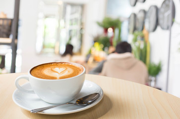 Hot art Latte Coffee in a cup on wooden table and Coffee shop bl