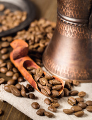 Showel with coffee beans and turkish coffee brewing pot