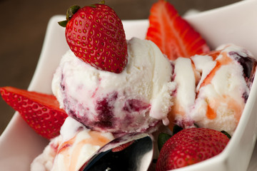 Strawberry icecream in a white bowl  with strawberries