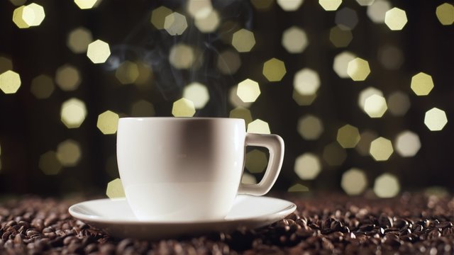 Coffee cup and saucer on a wooden table. Dark background.