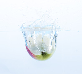 Fototapeta na wymiar Grüner Apfel fällt ins Wasser