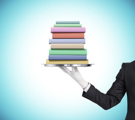 Man is keeping a tray with pack of books