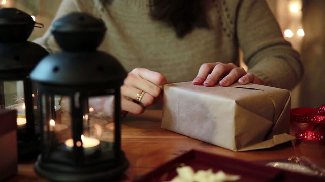 Women's Hands Wrapping Christmas Gifts At Home