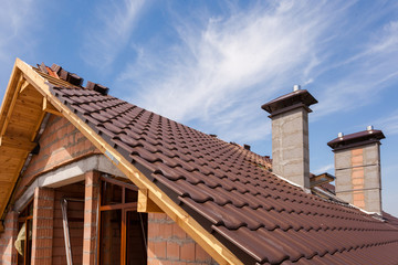 View on the tiled roof with chimneys from second floor of a new house