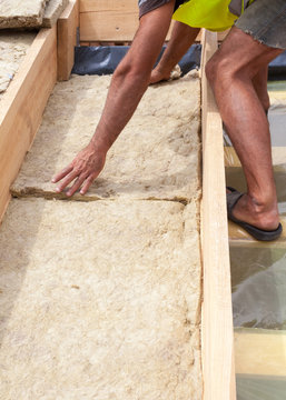 Roofer builder worker installing roof insulation material