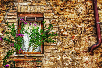 rustic window in a brick wall in San Gimignano - obrazy, fototapety, plakaty