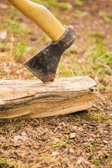 Old ax stuck in a wooden log