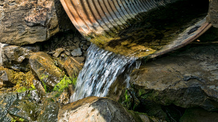 Water draining from a culvert - obrazy, fototapety, plakaty