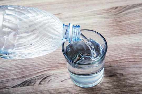 bottiglia versa acqua in un bicchiere di vetro trasparente