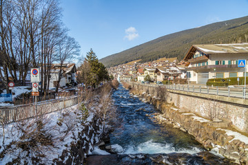 Fototapeta na wymiar river through snowy alpine village