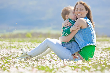 Fototapeta premium Happy mother with son in a flowers field 