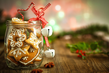 Christmas Cookies in a jar  on Wooden background with Christmas Holly - obrazy, fototapety, plakaty