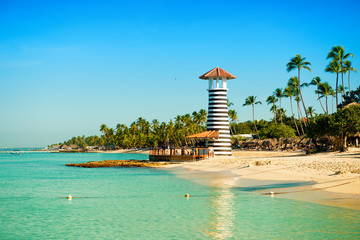 Paradise tropical island in Dominican Republic. White sand, blue sea, clear sky and  lighthouse on shore