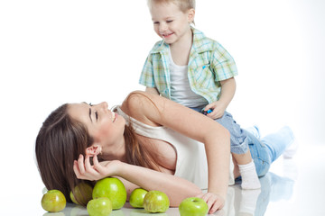 Fototapeta premium Mother with son are eating apples in studio